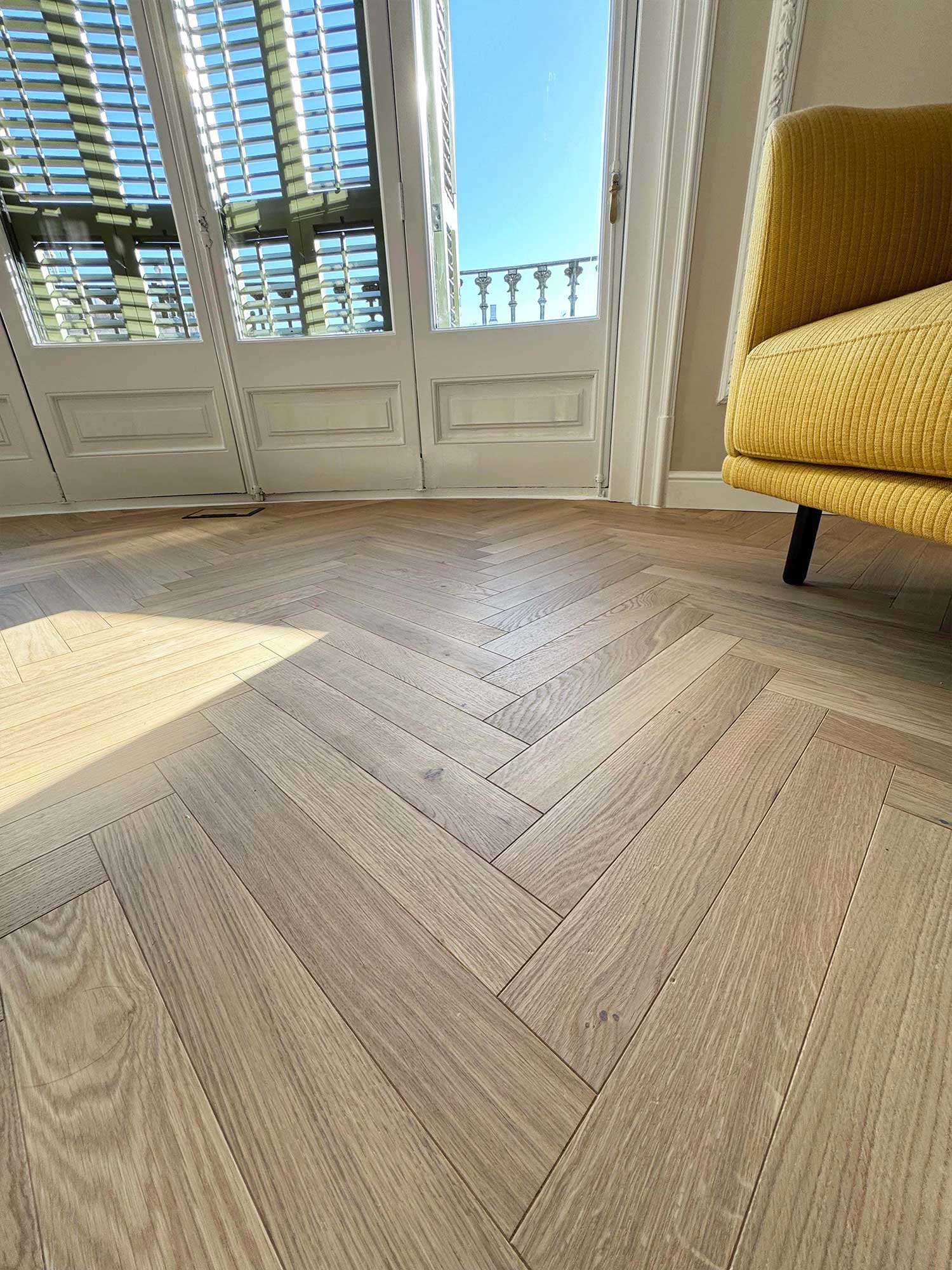 Detalle del parquet en espiga de roble natural en la reforma de unas oficinas de la calle Córcega.