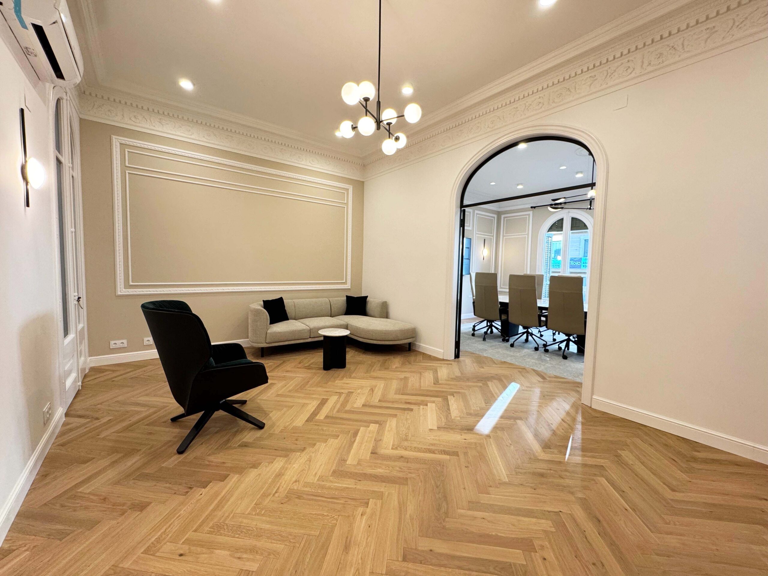Sala con molduras clásicas y parquet en espiga FRV Comfort instalada por WINco en un proyecto corporativo del Eixample.