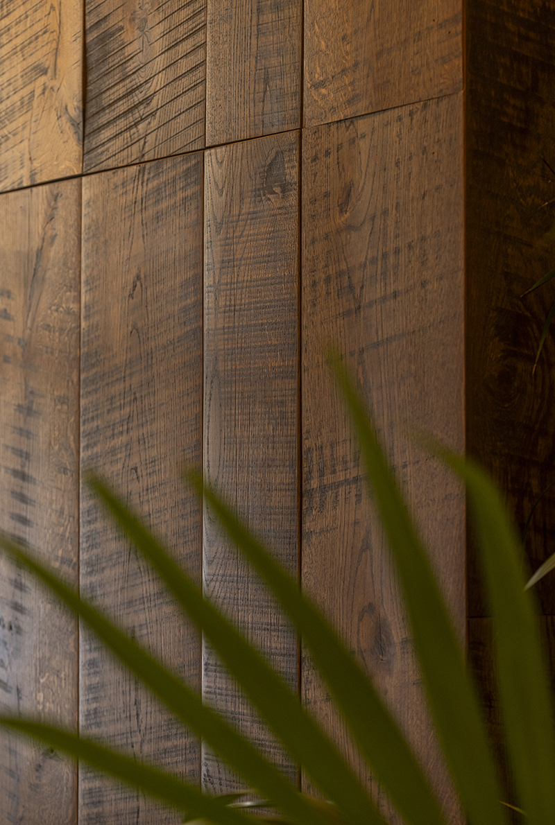 Detalle de revestimiento de madera envejecida en pared del Hotel Medinaceli, textura cepillada y acabado cálido