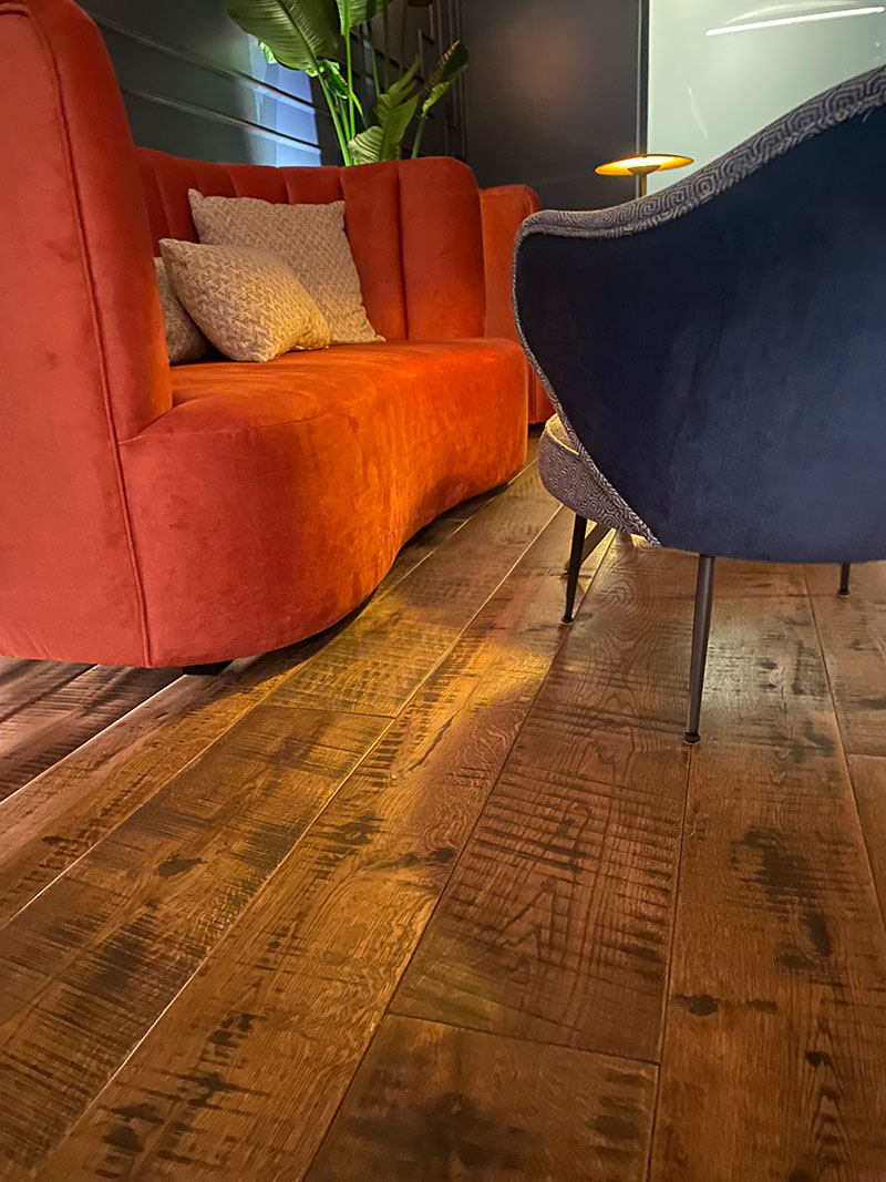 Continuidad material en suelo y pared con parquet Copenhaguen de roble envejecido instalado por WINco en el Chapter 8.