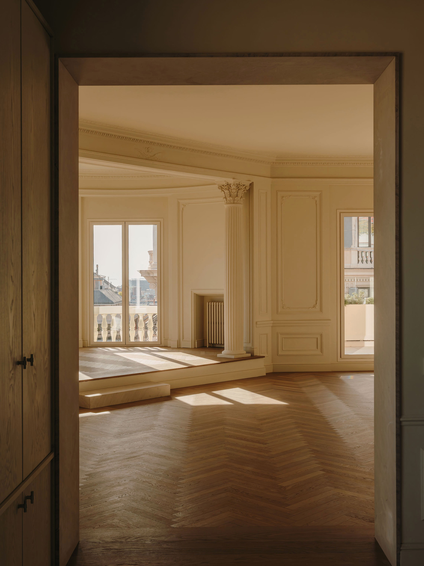 Salón de ático clásico en Barcelona con parquet en espiga de madera natural