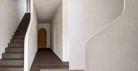 Parquet premium Belgiqa Oak Eight Mineral Brown de roble europeo en una vivienda contemporánea con continuidad entre suelo y escalera