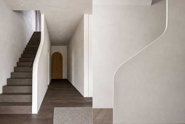 Parquet premium Belgiqa Oak Eight Mineral Brown de roble europeo en una vivienda contemporánea con continuidad entre suelo y escalera