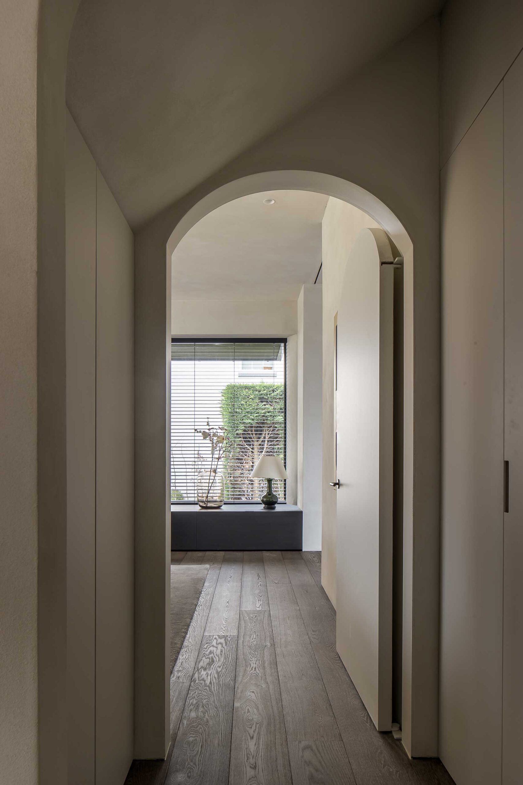 Parquet de roble europeo Belgiqa Mineral Brown en zona de paso con arco interior y arquitectura contemporánea
