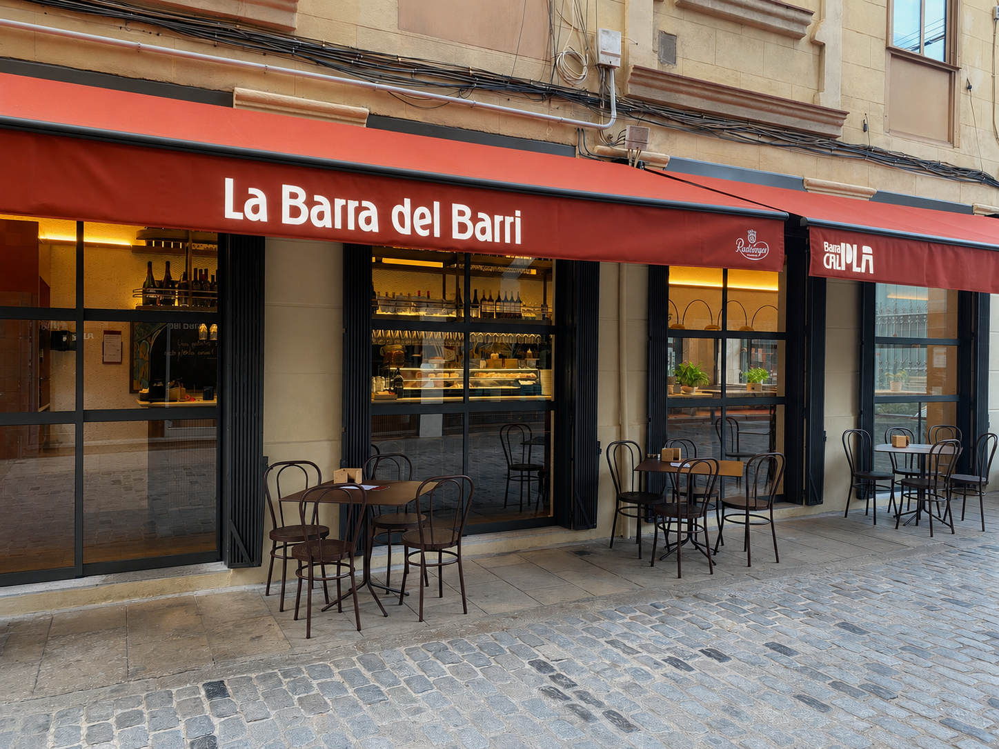 Fachada exterior de Barra Cal Pla 1965 en Barcelona, con terraza y mesas en la calle Fachada exterior de Barra Cal Pla 1965 en Barcelona, con terraza y mesas en la calle