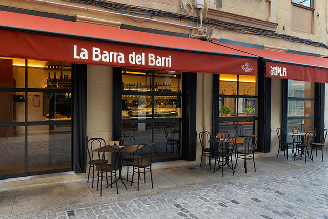 Fachada exterior de Barra Cal Pla 1965 en Barcelona, con terraza y mesas en la calle